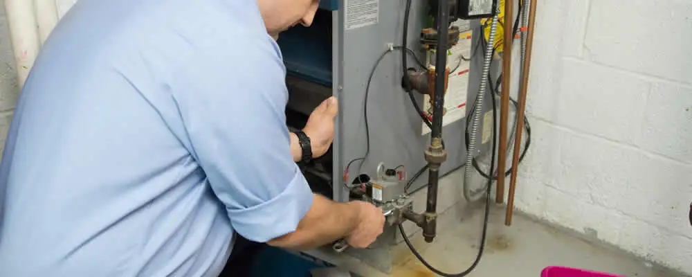 Furnace repair technician inspecting and servicing a home heating system in Pasadena, CA