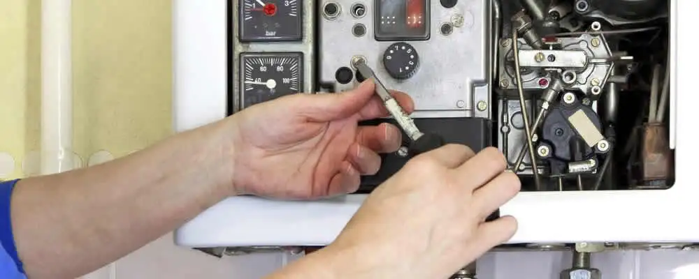Heating repair technician adjusting boiler controls and components in Pasadena, CA