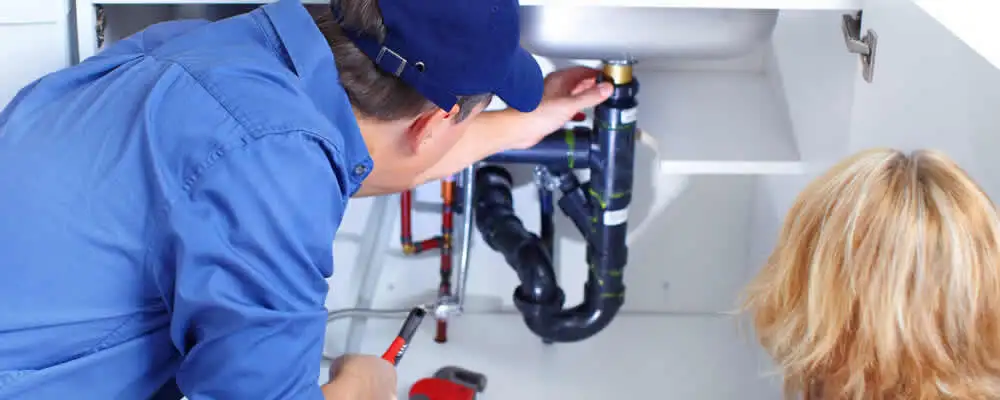Plumber repairing under-sink drain pipes and fittings in Pasadena, CA
